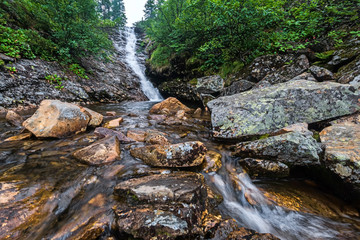Obraz premium Waterfall on a mountain stream in Khamar-Daban ridge