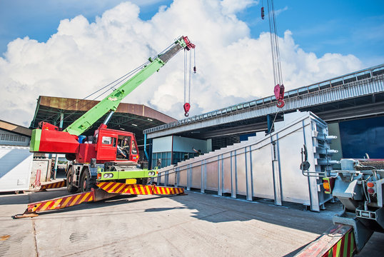 Mobile crane lifting and moving an heavy electric generator