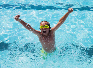 Cheerful boy in goggles in swimming pool

