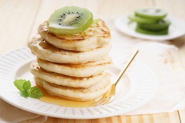 pancakes with honey syrup and fresh kiwi sliced