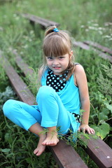 little girl with long hair playing on grass in summer