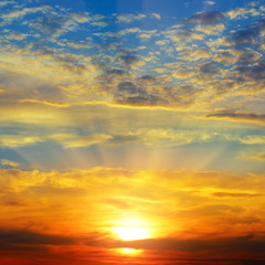 Sunset over the horizon. Sky with colored clouds.