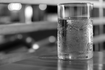 Cold water in a glass On the table, black and white.