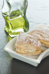 Puff pastry cake with cream and powdered sugar