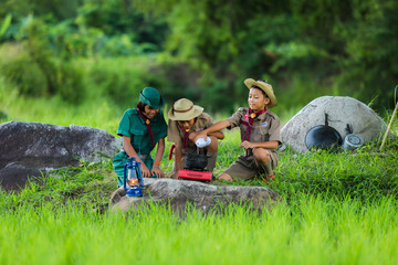 Boy Scout and girl scout in Camp to help themselves to the food as part of the study. - obrazy, fototapety, plakaty