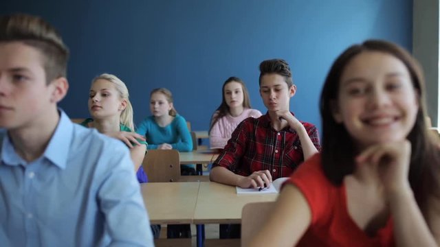 students with notebooks writing test at school