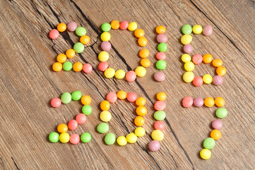2016 2017 written with colorful candies on wooden background