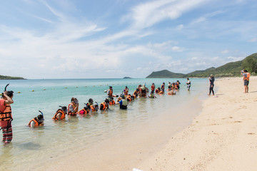 Asian tourists are practice snorkeling on seaside