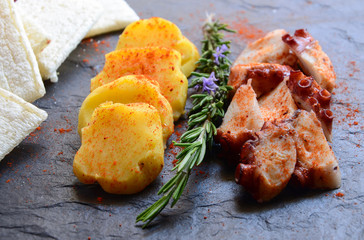 Delicious Galician octopus (Pulpo a la gallega or Pulpo a Feira) served with potatoes and hot pepper. Typical spanish tapas.