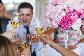 Closeup of clanging glasses full of white wine