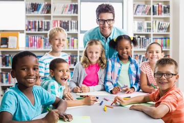 Fototapeta premium Portrait of teacher and kids in library