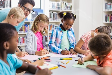 Teacher helping kids with their homework in library
