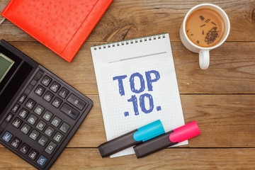 Working space. Green tea and text in notepad: Top 10