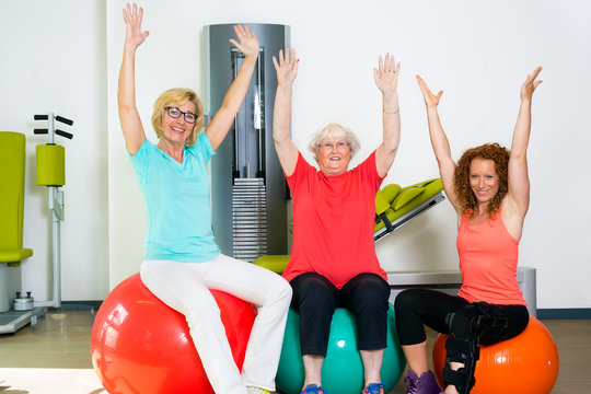 Happy patients with instructor stretching arms.