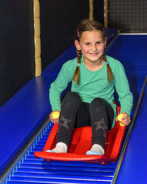 Mädchen fährt auf einer Rollschlittenbahn im Freizeitpark