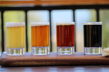 A selection of four different craft beers on a wooden board