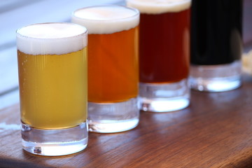 A selection of four different craft beers on a wooden board