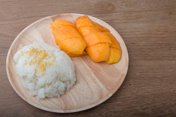 sweet sticky rice with mango coconut milk on wood