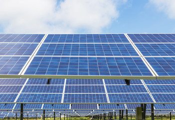 Photovoltaics module solar panels in solar farm  station on blue sky background.