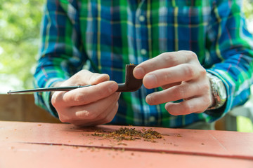 Man fills his pipe with tobacco