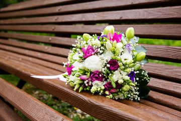 Fototapeta na wymiar Beautiful bridal bouquet of flowers on wooden bench