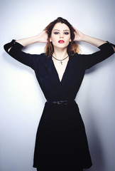 Fototapeta premium Portrait of beautiful brunette woman in black dress. Fashion photo