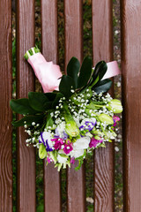 Beautiful bridal bouquet of flowers on wooden bench