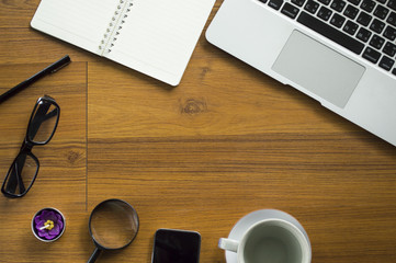 Office table with notepad, laptop and coffee cup.View from above with copy space.