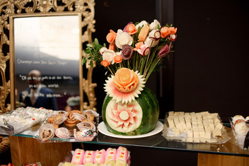 Watermelon with original flower design stands on the buffet with
