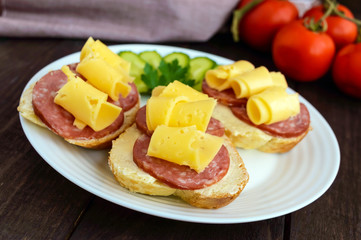 Classic sandwich with sausage and cheese on white baguette. Breakfast