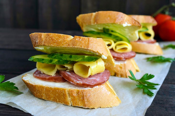 Classic sandwich with sausage and cheese on white baguette. Breakfast