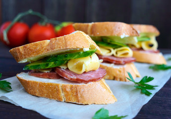 Classic sandwich with sausage and cheese on white baguette. Breakfast