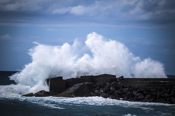 Stone breakwater with breaking waves.