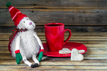 Obraz na płótnie Canvas Christmas, red Cup with coffee and dessert on wooden background