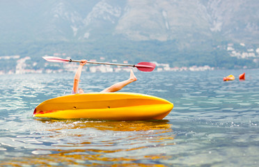 Mature man kayaking on the sea, falling out of the kayak