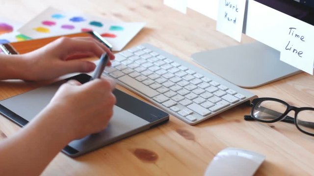 Web designer draws the layout of the site in his book and working on the computer.