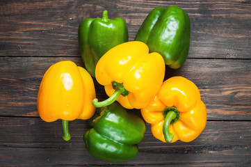 yellow and green paprika on wood background