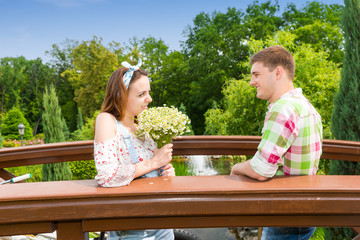 Fototapeta premium Happy young couple having a date on a bridge in the park