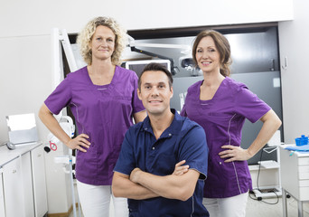 Confident Male Dentist With Female Assistants