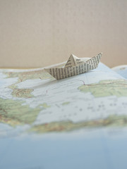 Paper boat on a map book