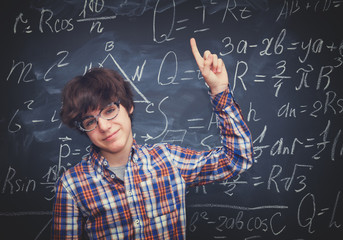 Boy and blackboard filled with math formulas