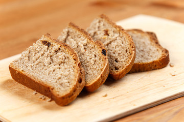 Fresh bread slices on rustic wooden board