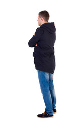 Back view of handsome man in winter jacket  looking up.   Standing young guy in parka. Rear view people collection.  backside view of person.  Isolated over white background. Man in warm jacket is