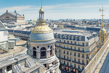 Paris aerial view, domes on the rooftop of gallery printemps and opera house. Traditional parisian architecture with mansards and chimneys