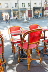 Fototapeta na wymiar Paris street cafe with red wicker furniture. Cozy outdoor cafe in Paris, France.
