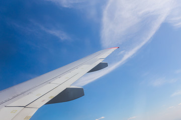 View from airplane window with blue sky and white clouds