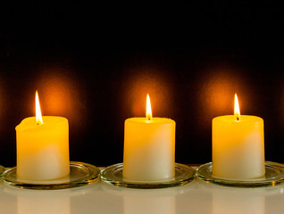 closeup to burning candles in darkness