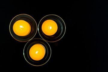 closeup to burning candles in darkness