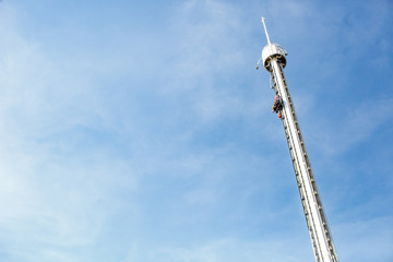 White tower raises over the amusement park up in the air