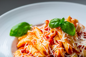 Pasta Penne with Tomato Bolognese Sauce, Parmesan Cheese and Basil Leaves. Mediterranean food.Italian cuisine.
